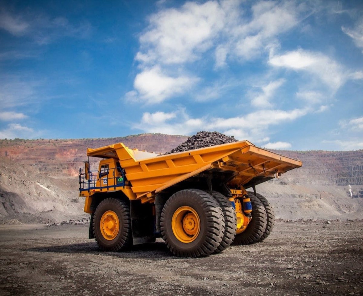 Heavy mining dump truck loaded with ore at an open-pit site